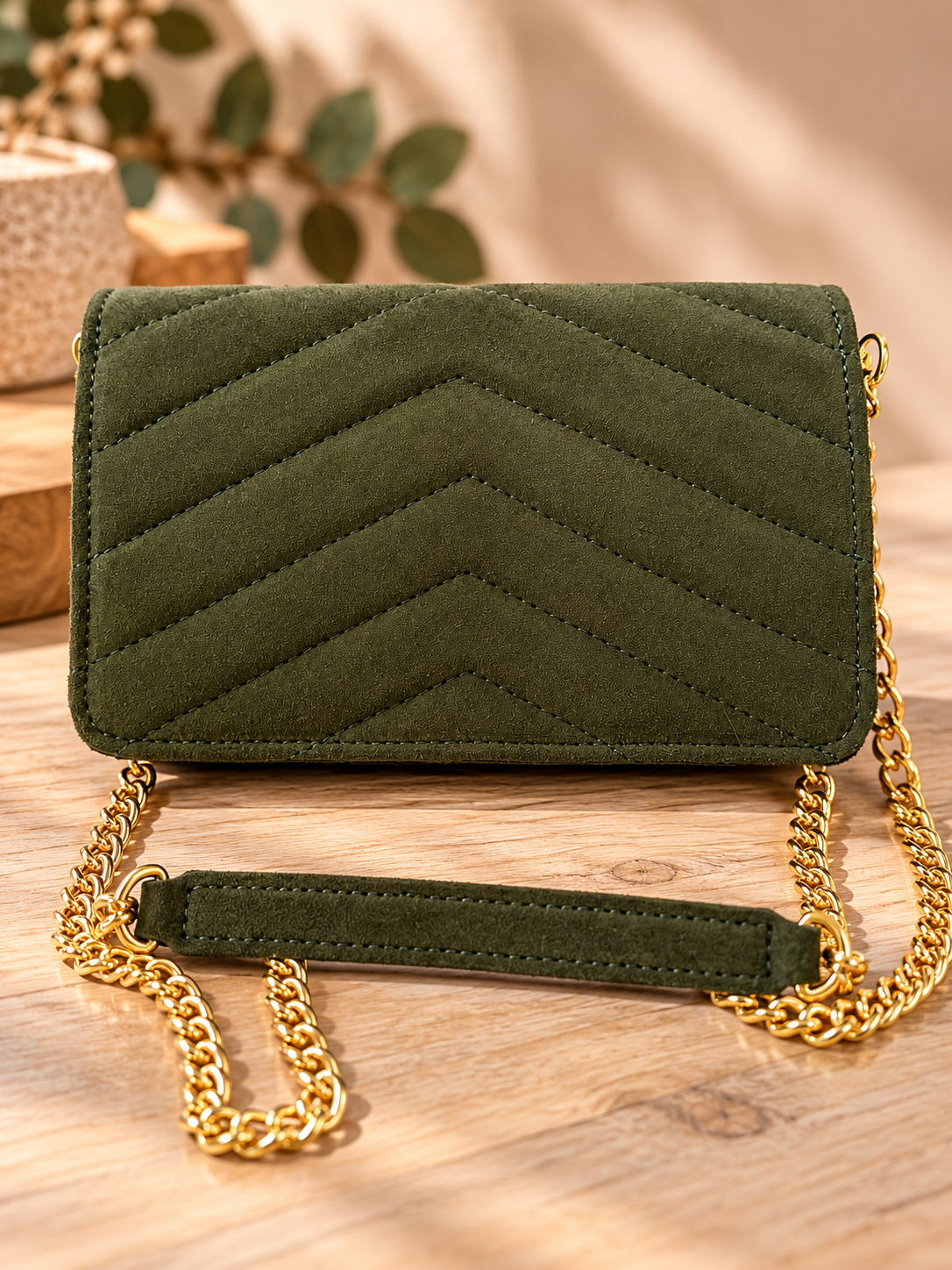 Olivgrüne Wildleder-Clutch mit Goldkette – Studioaufnahme