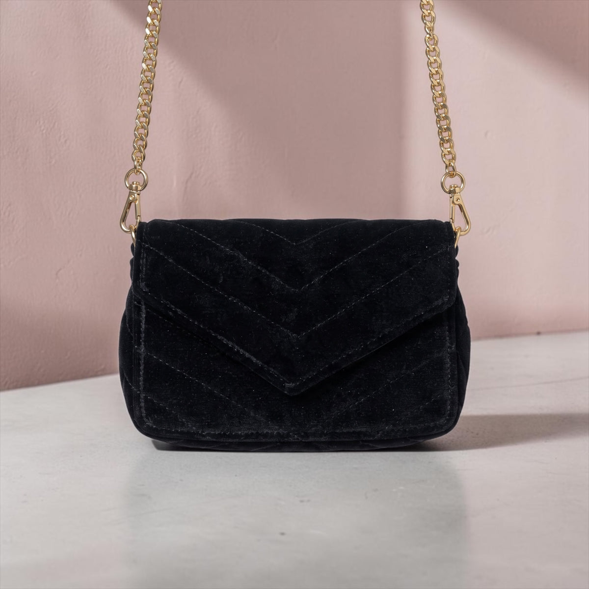 Schwarze Wildleder-Clutch mit Goldkette